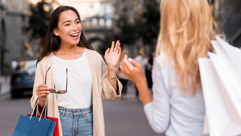 Asian woman greeting another woman