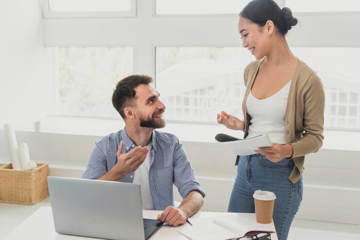 man setting with his laptop chatting with a woman